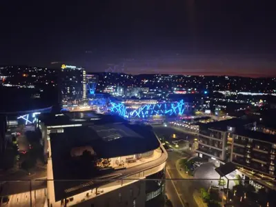 a view of a city at night with a building at Menlyn Maine Trilogy Apartment 101 in Pretoria