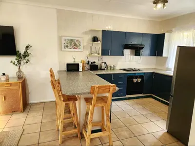a kitchen with blue cabinets and a table and chairs at The Grace in Pretoria