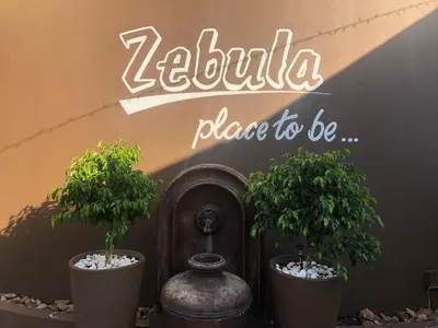 two potted trees in pots in front of a sign at Zebula Golf and Wildlife Estate - Open Plains Pax 10 - Moi Signature Luxury villa in Mabula