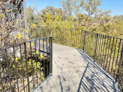 a walkway with a metal fence and trees at Spacious 2 Bedroom Apartment in Midrand, Waterfall City - Business and Family friendly - 12 Elizabeth Place in Midrand