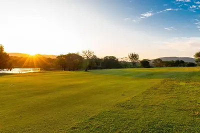 a field of green grass with the sun in the background at Kruger Park Lodge Unit No. 516 in Hazyview