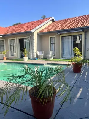 a house with potted plants next to a swimming pool at MorningMist Boutique Sun in Centurion