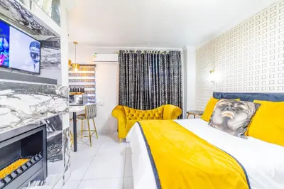 a hotel room with a yellow bed and a tv at Homes of Ace Diamond in Pretoria
