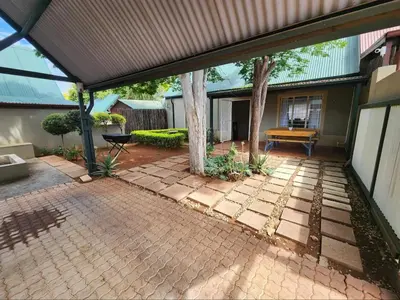 an open patio with a tree in the middle at Baruch in Pretoria