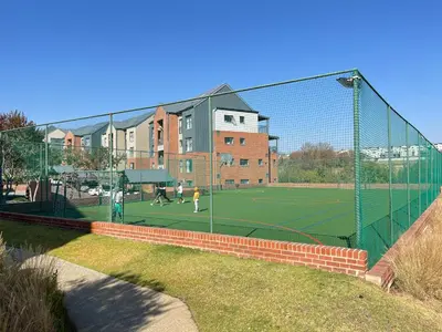 a tennis court with people playing tennis on a court at 4 Elizabeth Place - Beautiful 1 bedroom unit next to Kyalami Racetrack with free WiFi swimming pool gym and restaurant - Perfect for a Couple in Midrand Waterfall in Midrand