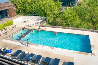 an overhead view of a swimming pool with people in it at 10 Elizabeth Place - Beautiful self catering 2 bedroom unit next to Kyalami Racetrack with free WiFi swimming pool gym and restaurant - Perfect for a small family in Midrand Waterfall in Midrand