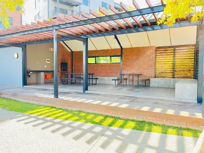 a patio with tables and benches in a brick building at 10 Elizabeth Place - Beautiful self catering 2 bedroom unit next to Kyalami Racetrack with free WiFi swimming pool gym and restaurant - Perfect for a small family in Midrand Waterfall in Midrand