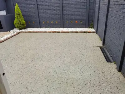a garden with a retaining wall and a driveway at Beautiful apartment behind Illanga Mall in Mataffin