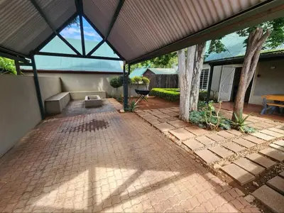 a pavilion with a brick patio with a tree at Selah, self-catering in Pretoria