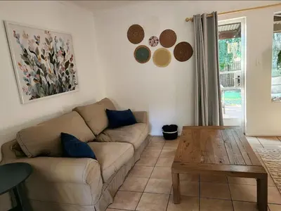 a living room with a couch and a wooden table at Selah, self-catering in Pretoria