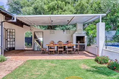 a patio with a wooden table and chairs at The Cottage-1 Bed-pool-bbq-fibre-solar-samrand in Centurion