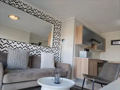 a living room with a couch and a table at Greencreek Riverwalk in Pretoria