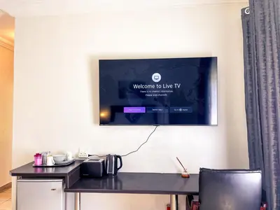 a television hanging on a wall with a desk at Bobisemo Luxury Guesthouse in Pretoria