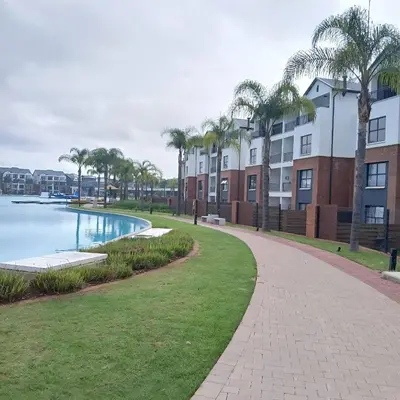a walkway next to a pool with palm trees at The Blyde 2 bedrooms Luxe Marvelous Apartment in Pretoria