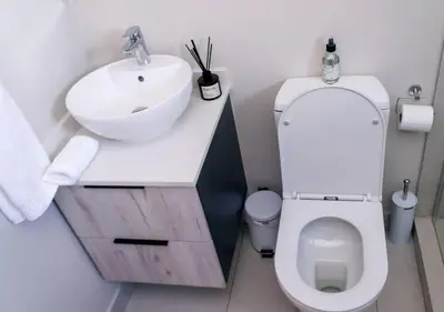 a bathroom with a white sink and a toilet at Luminant Escapes - with power backup in Midrand