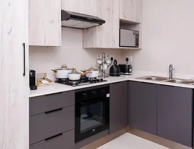 a kitchen with a stove top oven next to a sink at Luminant Escapes - with power backup in Midrand