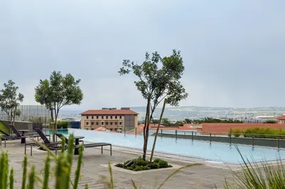 a swimming pool with a tree and a building at Elipse Waterfall-2802 in Midrand