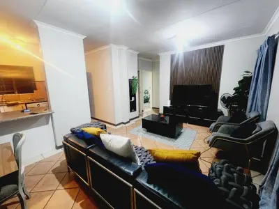 a living room with a couch and a television at Lions Haven in Pretoria