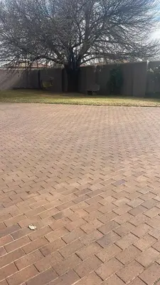 a brick parking lot with a tree in the background at Pringle Cottage in Benoni