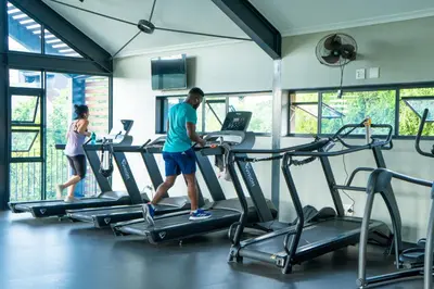 a man and a woman walking on treadmill in a gym at Spacious 2 Bedroom Apartment in Midrand, Waterfall City - Business and Family friendly - 14A Elizabeth Place in Midrand