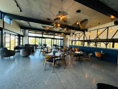 a restaurant with tables and chairs and windows at Secure 1 Bedroom Apartment in Midrand, Waterfall City - Lock Up and Go - Free WIFI and Parking - 6A Elizabeth Place in Midrand
