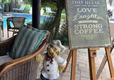 a teddy bear sitting in a chair next to a sign at The Presidential Suite at Frederick's Place in Pretoria