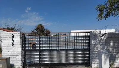 a black gate on a white brick wall at Blessing secure unit in Pretoria