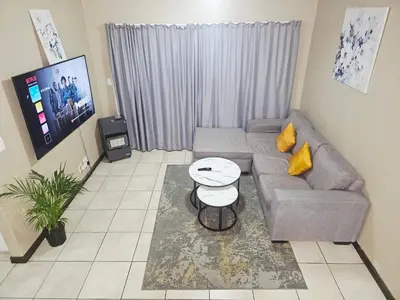 a living room with a couch and a table at Welcome Home in Midrand