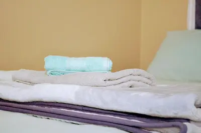a pile of towels sitting on top of a bed at Welcome Home in Midrand