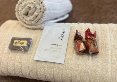 a packet of chocolates and a bar of chocolate on a towel at The Elephant Room at Frederick's Place in Pretoria