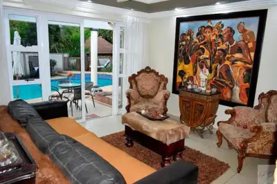 a living room with a large painting on the wall at The Elephant Room at Frederick's Place in Pretoria