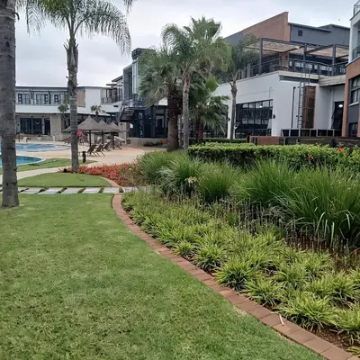 a walkway in front of a resort with palm trees at The Blyde 2-Bed Luxe Apartment in Pretoria