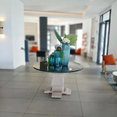 a table with a blue vase with flowers on it at The Blyde 2-Bed Luxe Apartment in Pretoria