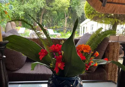 a blue vase filled with flowers on a table at The Lion Room at Frederick's Place in Pretoria