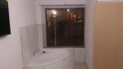 a white bath tub in a bathroom with a window at Thiwani Guest House in Tembisa