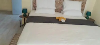 a bed with a stuffed animal sitting on top of it at PK house in Mbabat