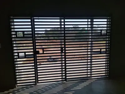 a large window with blinds on it in a room at Zinnia house in Midrand