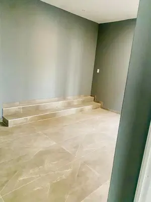 an empty room with a stone floor and stairs at Zinnia house in Midrand