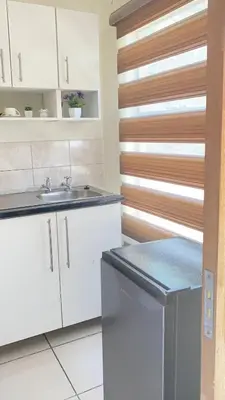 a kitchen with white cabinets and a sink at Giraffe camel in Phalaborwa