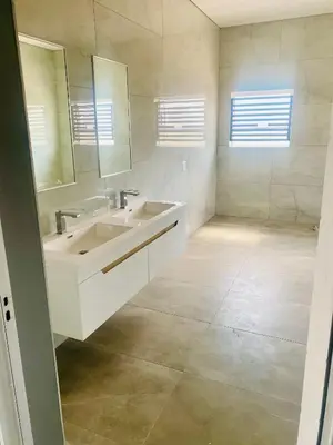 a white bathroom with a sink and a mirror at 114 Zinnia in Midrand
