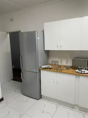 a kitchen with white cabinets and a stainless steel refrigerator at Palma de Mallorca in Kempton Park