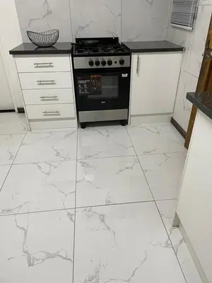 a kitchen with white marble floors and an oven at Travelers Standard in Kempton Park