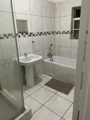 a bathroom with a sink and a tub and a toilet at Torremolinos City in Kempton Park