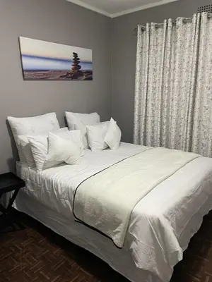 a bedroom with a large bed with white sheets and pillows at Torremolinos City in Kempton Park