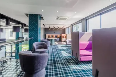 a waiting room with purple and pink chairs and tables at 1 bedroom Apartment in Pretoria