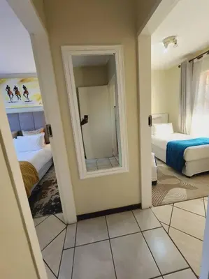 a room with two beds and a mirror at 2d - 50 No load shedding - 2 bedroom in Centurion