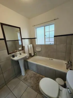 a bathroom with a tub and a toilet and a sink at 2b - 74 No load shedding - 2 bed home in Centurion