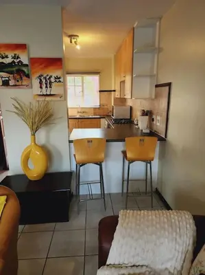 a kitchen with a table and chairs in a room at 2b - 74 No load shedding - 2 bed home in Centurion