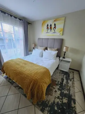 a bedroom with a large bed and a large window at 2b - 74 No load shedding - 2 bed home in Centurion
