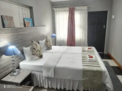 a bedroom with a large bed and a window at Home of peace and tranquility in Pretoria